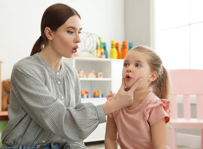 Speech Therapist Working With Little Girl In Office